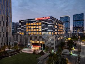 a building with a sign on the top of it at Hilton Garden Inn Nanjing Hexi Olympic Sports Center in Nanjing