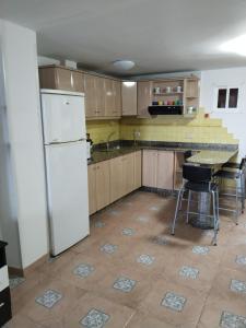 una cucina con frigorifero bianco e tavolo di Sweet Home Pozo Izquierdo A a Pozo Izquierdo