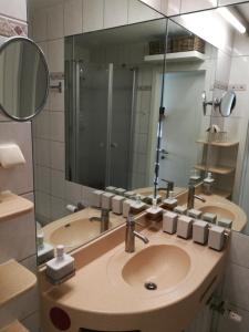 a bathroom with a sink and a large mirror at Top Appartment mit Weitblick und Late Check-Out inklusive aktivCARD in Sankt Englmar