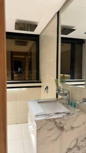a bathroom with a marble sink and a mirror at Damac Jeddah 1408 in Jeddah