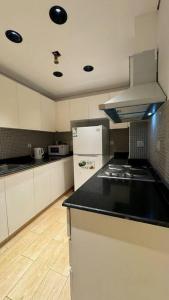 a kitchen with a black counter top and a refrigerator at Damac Jeddah 1408 in Jeddah