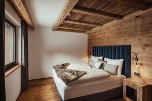 a bedroom with a bed with a blue headboard at Luxury Chalet P in Ortisei