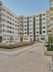 a large white apartment building with a courtyard at Take a cosy rest Near the airport in Nouaceur