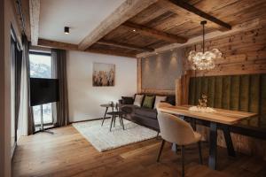 uma sala de estar com uma mesa e um sofá em Luxury Chalet P em Ortisei