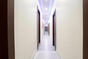 a hallway with white walls and a long corridor with lights at FabHotel Freedom International in Mumbai