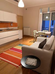ein Wohnzimmer mit einem Sofa und einer Küche in der Unterkunft A Casa di Eugenia in Battipaglia