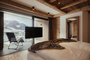 1 dormitorio con cama y ventana grande en Luxury Chalet P en Ortisei