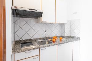 a kitchen with white cabinets and a sink at Residence Sabrina in Ceriale