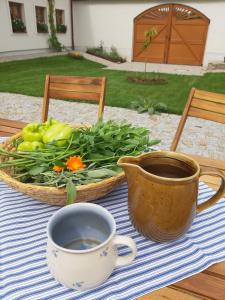 una mesa con una taza de café y una cesta de verduras en Apartmány Marie Albeř, en Nová Bystřice