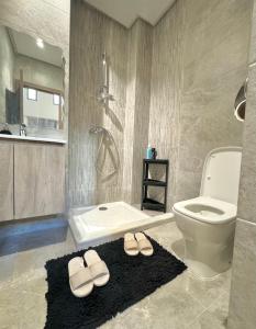 uma casa de banho com um WC e um par de chinelos. em Take a cosy rest Near the airport em Nouaceur