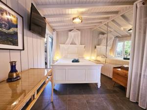 Villa African Queen - St Barth في غوستافي: غرفة نوم بيضاء مع سرير ومرآة