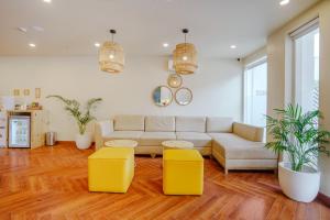 a living room with a couch and two yellow stools at Bloom Hotel - Karol Bagh in New Delhi