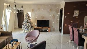 een woonkamer met een kerstboom en een televisie bij Apartman Fort in Stara Pazova