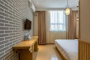a hotel room with a bed and a brick wall at Happy Dragon Alley Hotel Beijing Tian An Men Forbidden City in Beijing
