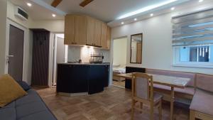 a kitchen and living room with a table and a couch at Vila Plan Karaman greben in Raška
