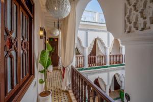 un corridoio con scala in una casa con una pianta in vaso di Riad Ekla Boutique Hotel a Marrakech