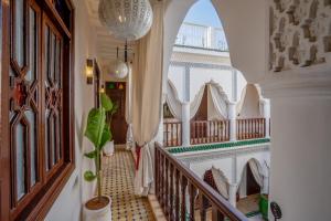 a hallway with a staircase in a house with a potted plant at Riad Ekla Boutique Hotel in Marrakech