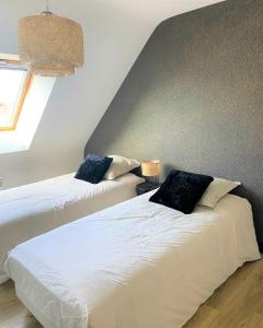 Dos camas una al lado de la otra en un dormitorio. en Maison Ty Rhuys avec piscine, en Saint-Gildas-de-Rhuys