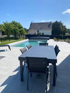 una mesa negra y sillas junto a una piscina en Maison Ty Rhuys avec piscine, en Saint-Gildas-de-Rhuys