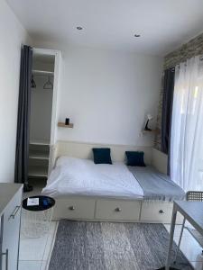 - une chambre avec un grand lit blanc et des oreillers bleus dans l'établissement Charmant studio de 18 m2., à Montarnaud