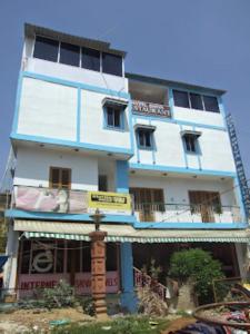 un edificio azul y blanco con un cartel delante en Hotel Shiva , Bodh Gaya, en Bodh Gaya