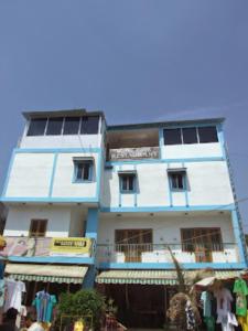 un edificio azul y blanco con gente delante de él en Hotel Shiva , Bodh Gaya, en Bodh Gaya