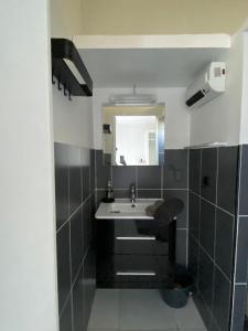 La salle de bains est pourvue d'un lavabo et d'un miroir. dans l'établissement Charmant studio de 18 m2., à Montarnaud
