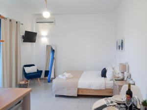 a bedroom with a bed and a table and a chair at Malamo Home Studios, Lambi Beach in Lampi