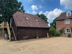 a building with a wooden garage with a wooden ladder at Hazelhurst - close to Bewl Water, Ticehurst in Wadhurst