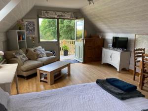 a living room with a bed and a couch at Hazelhurst - close to Bewl Water, Ticehurst in Wadhurst