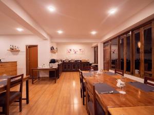 a large dining room with wooden tables and chairs at Kaya Gantavya Resort in Pelling