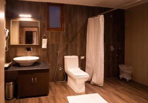 a bathroom with a toilet and a sink at Kaya Gantavya Resort in Pelling