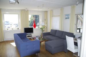 sala de estar con sofá azul y mesa en Haantjes Appartement Zeezicht en West-Terschelling