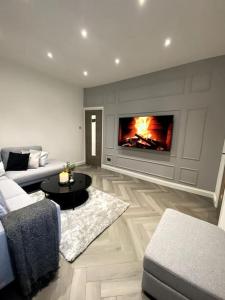 a living room with a couch and a fireplace at A home away from home in Manchester