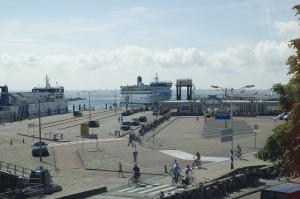 un grupo de personas montando bicicletas en una acera cerca del océano en Haantjes Appartement Zeezicht en West-Terschelling