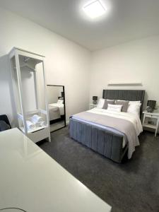 a bedroom with a large bed and a mirror at A home away from home in Manchester