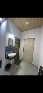 La salle de bains est pourvue d'un lavabo et d'une porte. dans l'établissement Dsouza's Nature Farm, à Badlapur