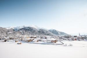 a town covered in snow with mountains in the background at Löwen Chalets in Seefeld in Tirol