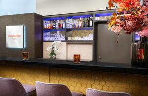 a bar in a restaurant with purple chairs at Leonardo Boutique Hotel Salzburg Gablerbräu in Salzburg