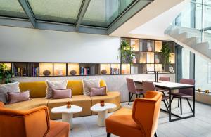 a lobby with a couch and tables and chairs at Leonardo Boutique Hotel Salzburg Gablerbräu in Salzburg