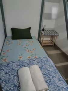 ein Bett mit zwei Handtüchern und einem Tisch in der Unterkunft EarlyHome@Adena- Graha Raya in Bendungan