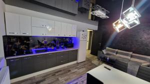 a kitchen with white cabinets and a couch at Apartamentul ALEX in Lupeni