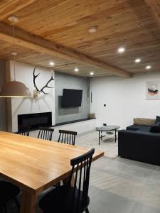 a living room with a table and a couch at Hill House Apartamenty in Białka Tatrzanska