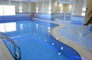 a large swimming pool with blue tiles in a building at Stunning 1 BR Apartment in Dubai Marina in Dubai