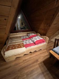 a bed sitting in the attic of a room at Apartamenty i Domki Taterka in Kościelisko