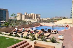 a swimming pool with lounge chairs and a swimming pool at Stunning 1 BR Apartment in Dubai Marina in Dubai