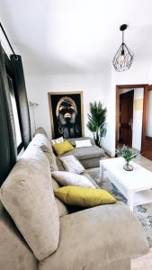 a living room with couches and a black mask on the wall at Apartamento Cruces in El Puerto de Santa María