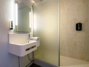 La salle de bains est pourvue d'un lavabo et d'une douche. dans l'établissement B&B HOTEL Brest Port du Moulin Blanc, à Brest