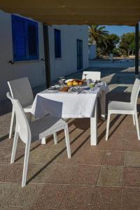 a white table and chairs with a plate of fruit on it at La Margherita Case Vacanze in Rodi Garganico