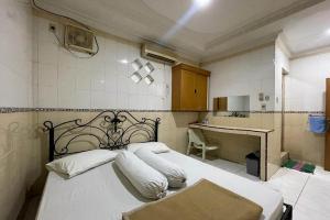 En eller flere senge i et værelse på OYO 93502 Homestay Pakmuklis Syariah 2